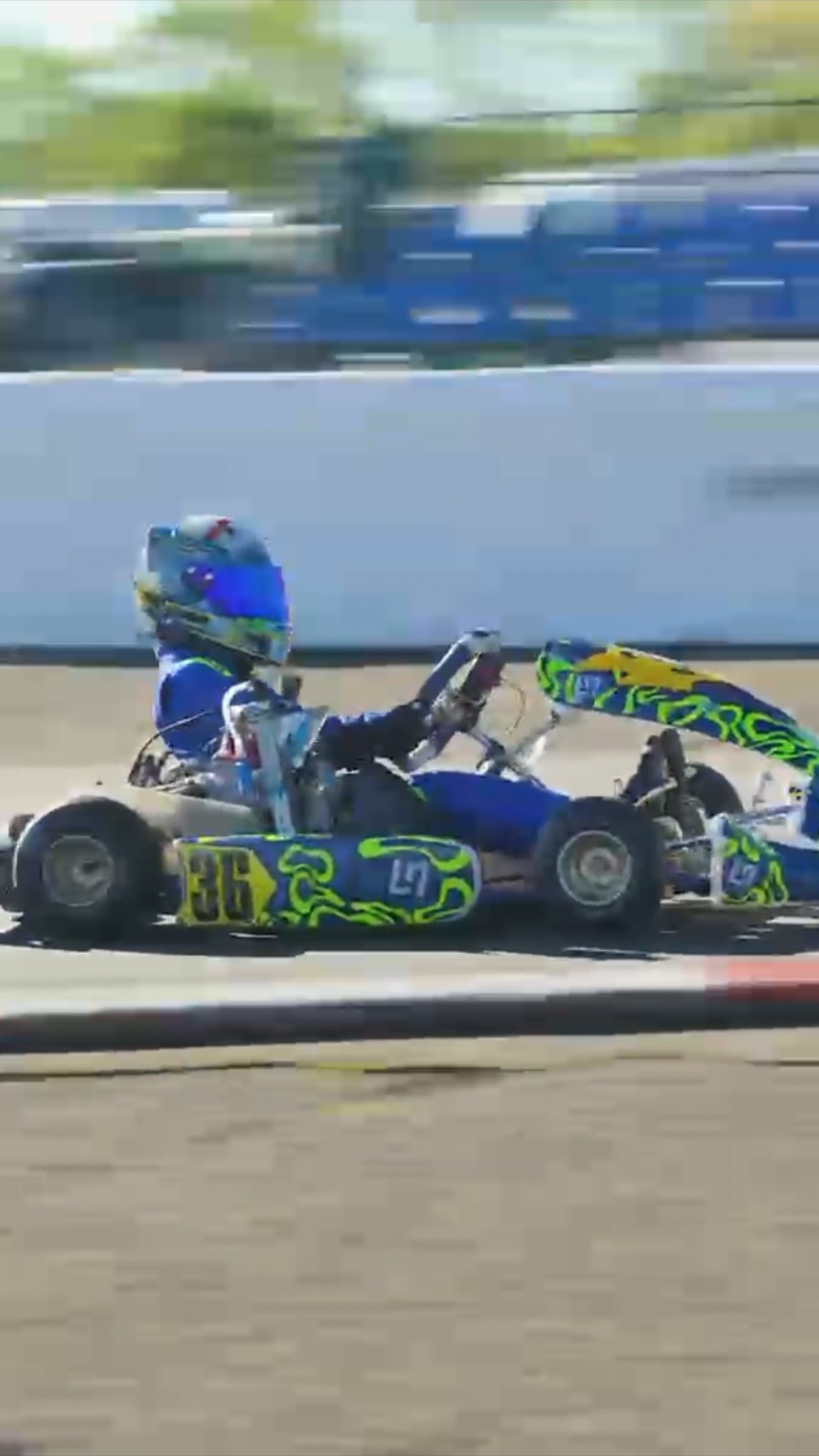 Finlay Rhodes driving his blue and fluorescent lime kart on track